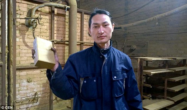 Brother Nut with a brick made out of dust particles he collected from the severe smog in Beijing over 100 days