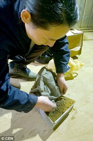 Making his brick, using dust collected over 100 days